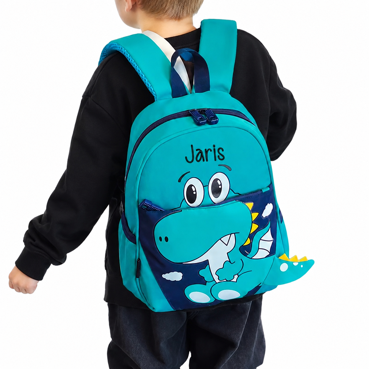 Personalisierbarer Kindergarten-Rucksack mit Dino-Design und Name Jaris, getragen von einem blonden Jungen im schwarzen Pullover
