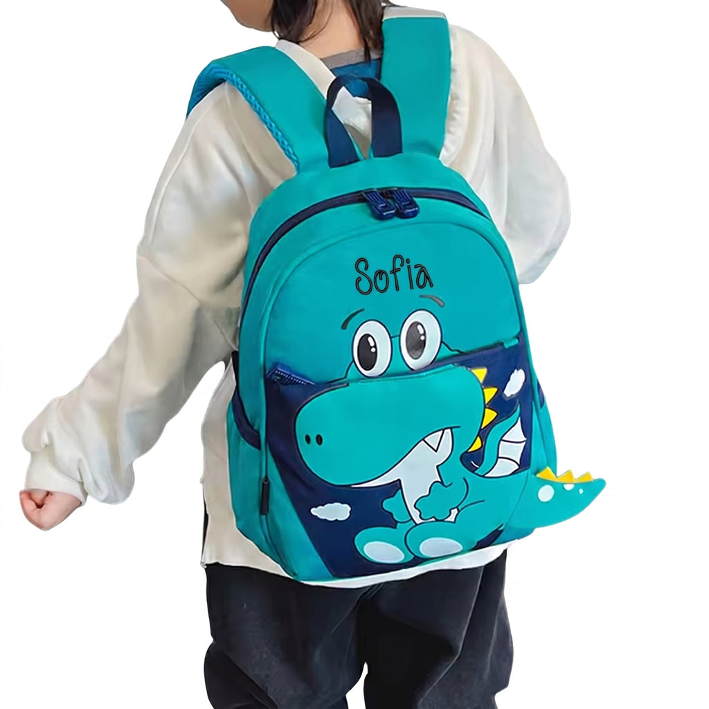 Personalisierbarer Kindergarten-Rucksack in Grün mit Dinosaurier-Motiv und Name, getragen von einem Kind für Kita und Kindergarten